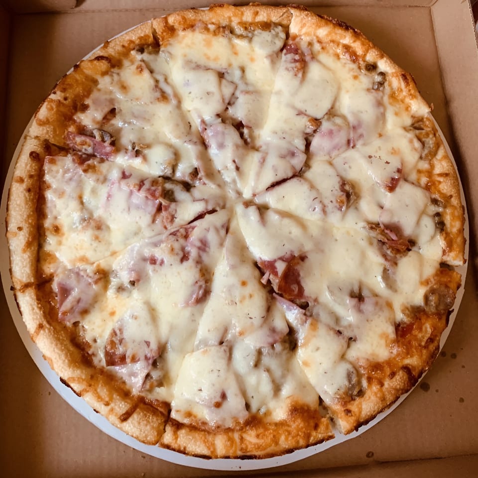 A freshly baked, sliced Angelina's Pizza with melted cheese and various toppings in a cardboard box.