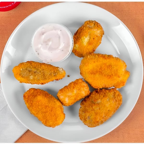 Six golden-brown fried appetizers and a small cup of dipping sauce on a white plate.