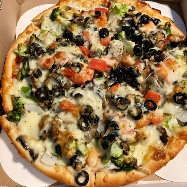 Angelina's Pizza whole vegetarian pizza with broccoli, olives, tomatoes, and mushrooms in a box.